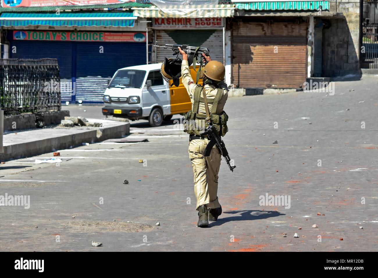 Srinagar, Kashmir. Mai 25, 2018 - Srinagar, J&K, - Ein indischer Polizist soll sein Gewehr an Kaschmir Demonstranten (nicht dargestellt) bei Zusammenstößen in Srinagar, Indien verwalteten Kaschmir. Heftigen Auseinandersetzungen zwischen Regierungstruppen und Kaschmir Demonstranten in Baku am Freitag. Zahlreiche Menschen wurden verletzt, nachdem Regierungstruppen Schrotflinte Pellets befeuert und Rauch Muscheln auf Kaschmir Demonstranten, die nach dem obligatorischen Freitag gemeindliche Gebete gesammelt. Credit: Saqib Majeed/SOPA Images/ZUMA Draht/Alamy leben Nachrichten Stockfoto