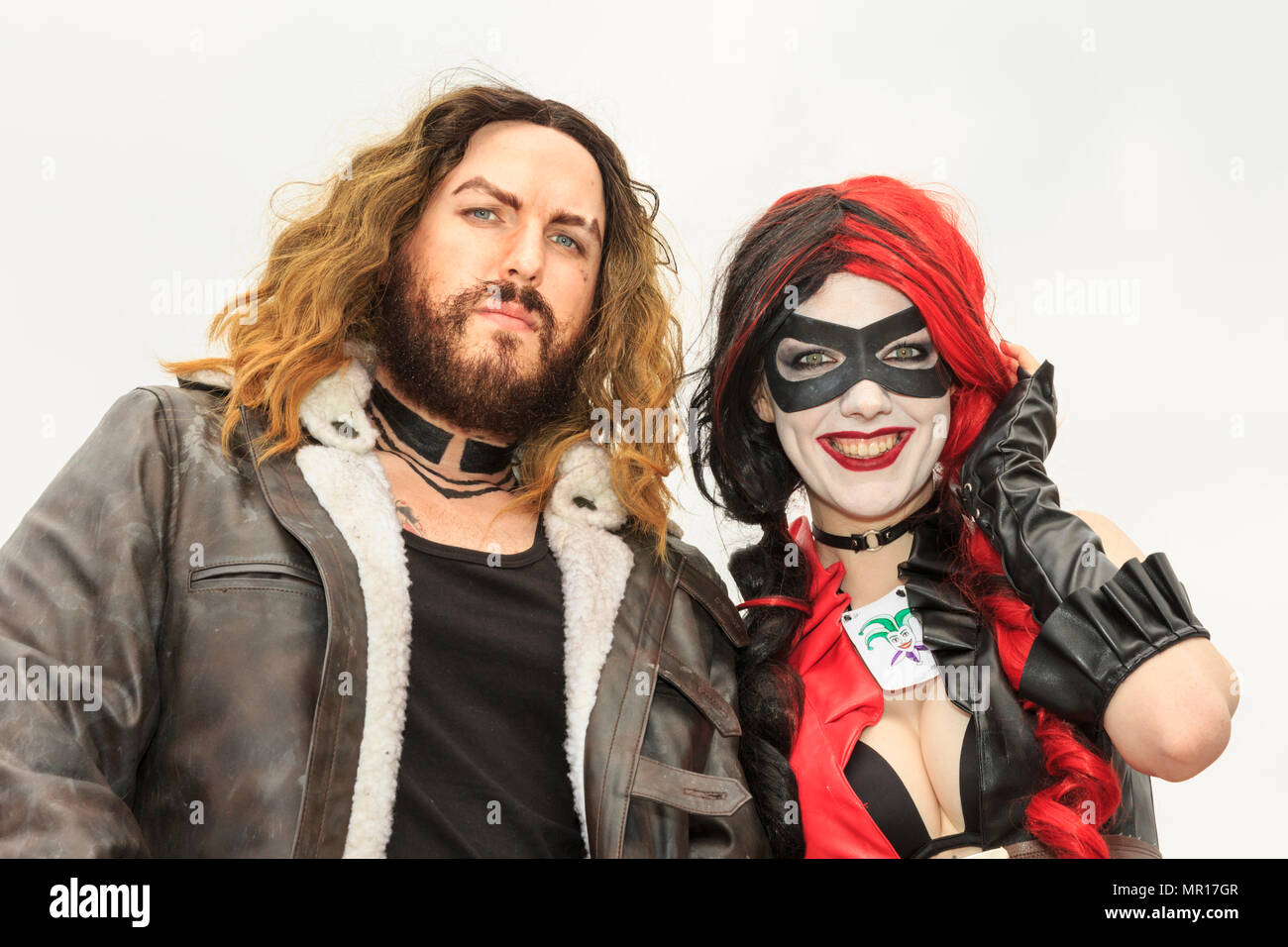 ExCel, London, 25. Mai 2018. Weibliche Cosplayer gekleidet, wie Batman und Harley Quinn's Harley Quinn, mit roten und schwarzen Bangs, während ihre Begleiter Schauspieler Jason Momoa ähnelt (Spiel der Throne, Aquaman, etc.). Cosplayer, Comic, Superhelden und kostümierte Besucher kommen zusammen für MCM Comicon Londons öffnung Tag 2018, ExCel Exhibition Centre 25. bis 27. Mai läuft. Credit: Imageplotter Nachrichten und Sport/Alamy leben Nachrichten Stockfoto