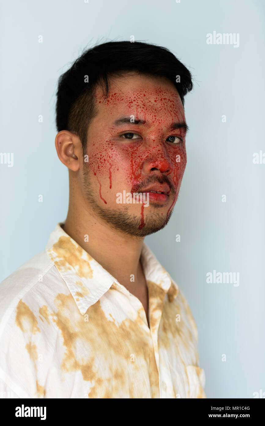 Gesicht der jungen verrückt asiatischer Mann mit Blut im Gesicht Stockfoto