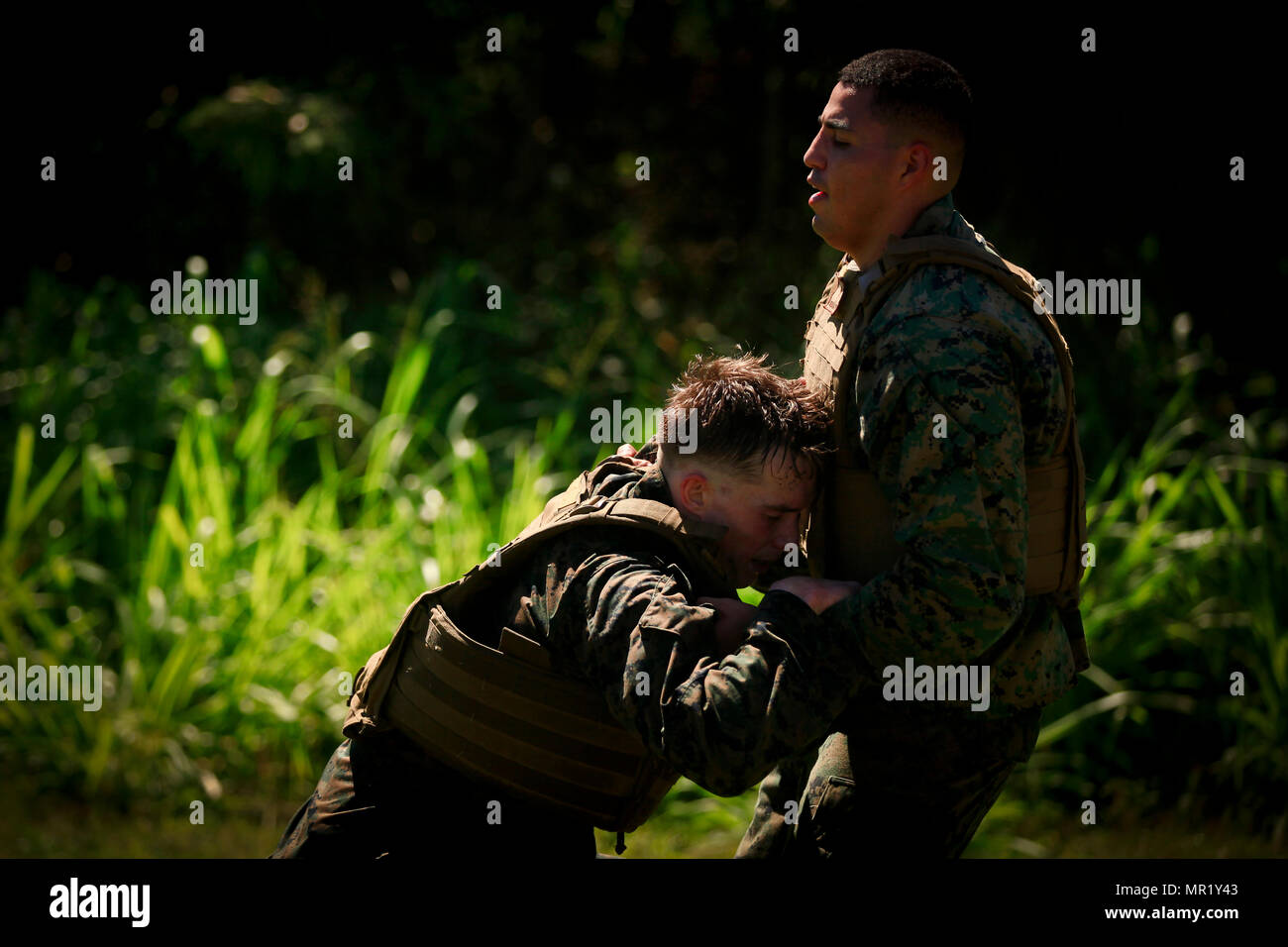 CPL. Garett Backer (links), eine Bekämpfung Fracht Marine mit der 11. Marine Expeditionary Unit, kollabiert nach Abschluss der kulminierende Fall von Martial Arts Instruktoren Kurs (MAIC) 1-17 an Bord der Marine Corps Base Hawaii, 1. Mai 2017. Die MAIC wird wöchentlich drei lange Gänge, die Bewerber durch hartes Training setzt zur Teamarbeit zu vermitteln und Führungsqualitäten erforderlich für einen Marine Corps Martial Arts Program Instructor, Unterricht zu entwickeln. Die Makin Island amphibische bereit Group/11th MEU läuft derzeit auf ihrer westlichen Pazifik 16-2-Bereitstellung. (U.S. Marine Corps Foto von Cp Stockfoto