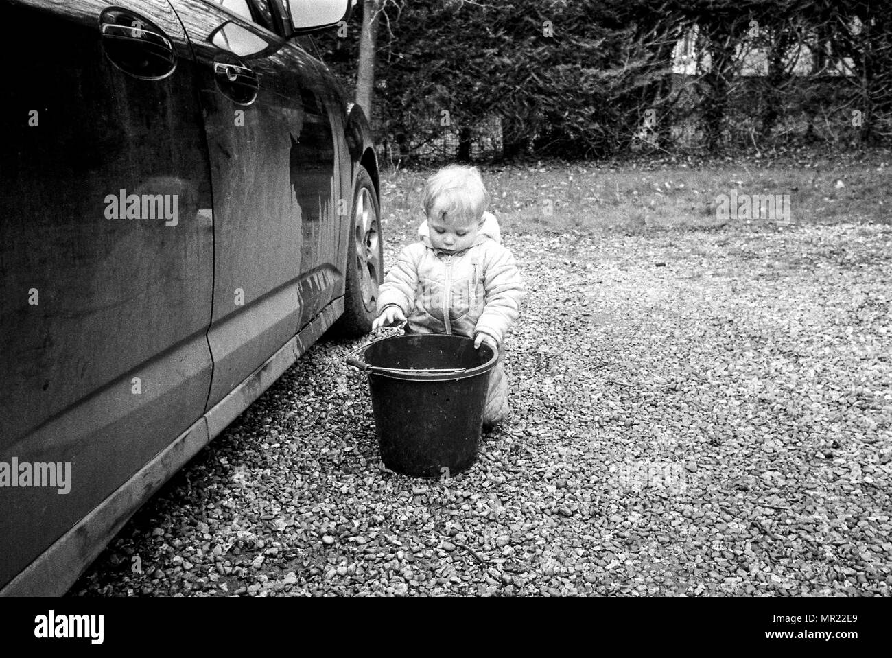 Baby Boy, ein Jahr (20 Monate) ein Auto waschen mit einem Schwamm. Stockfoto
