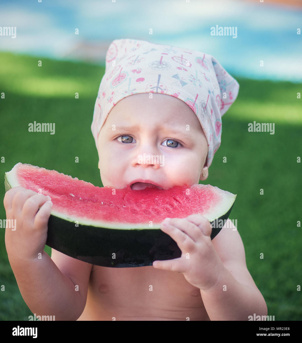 Schöne süsse Mädchen in ein Taschentuch isst, Wassermelone. Stockfoto