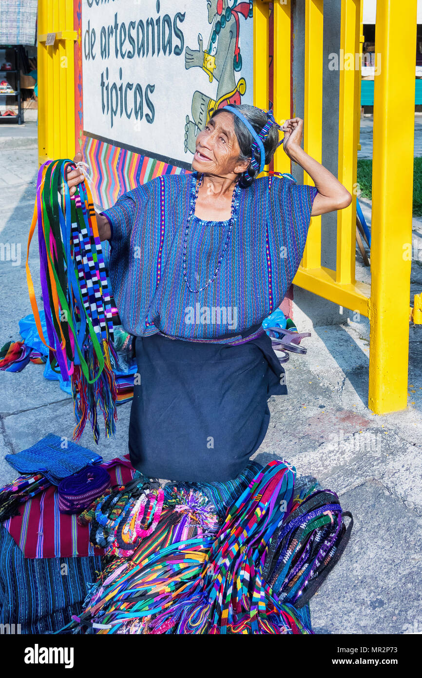 Panajachel, Guatemala - Dezember 8, 2016: Lokale Frau Verkauf auf der Hauptstraße in die geschäftige Stadt Panajachel. Händler verkaufen traditionelle Textilien. Die zu Stockfoto