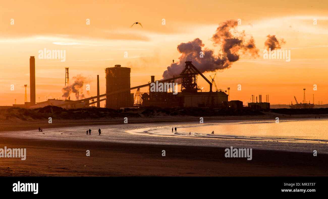 Sonnenuntergang Foto in Redcar, Blick zurück entlang der Küste in Richtung der Corus Stahl Anlage mit Zahlen am Strand Stockfoto