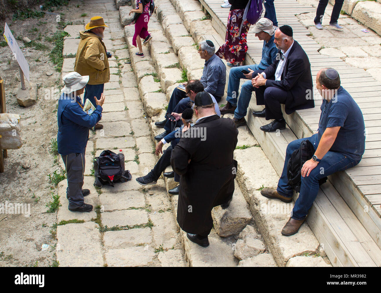 8. Mai 2018 eine kleine Gruppe jüdischer Männer sitzen auf den Stufen der Teich Siloah in Jerusalem hören auf einen Reiseführer. Stockfoto