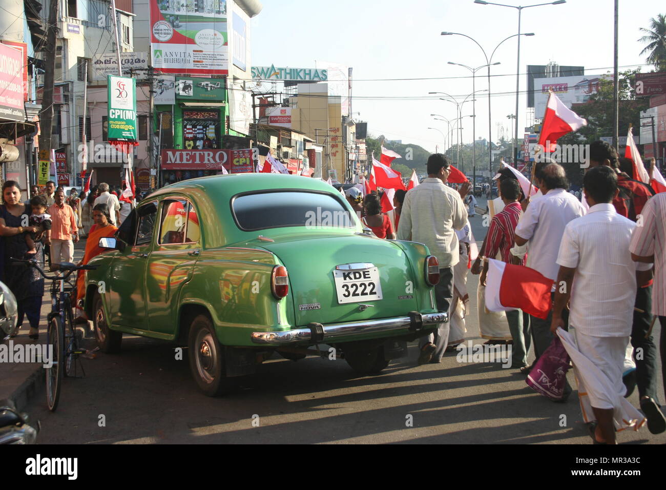 Die Demonstranten mit Fahnen und Grüne Botschafter Auto, Trivandrum, Indien Stockfoto
