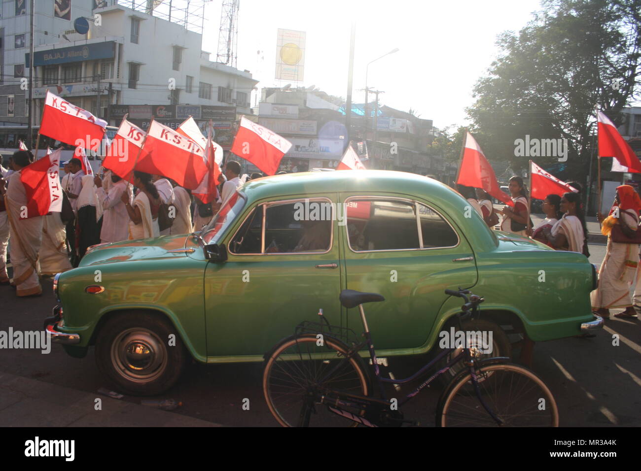 Die Demonstranten mit Fahnen und Grüne Botschafter Auto, Trivandrum, Indien Stockfoto