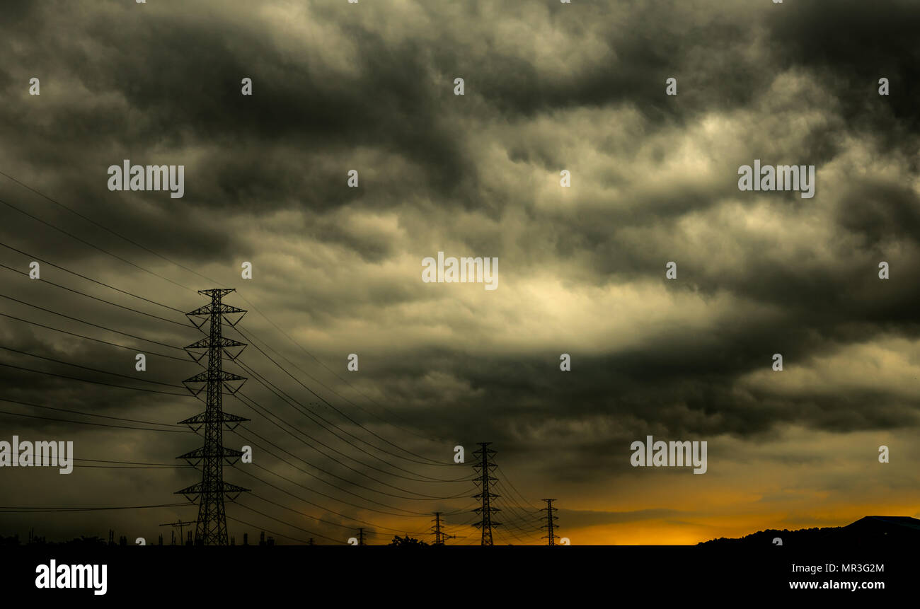 Dramatische dunklen Himmel und Wolken und hohe Spannung Pole mit elektrischer Kabel. Bewölkter Himmel Hintergrund. Black Sky vor Gewitter. Hintergrund für traurige, gri Stockfoto