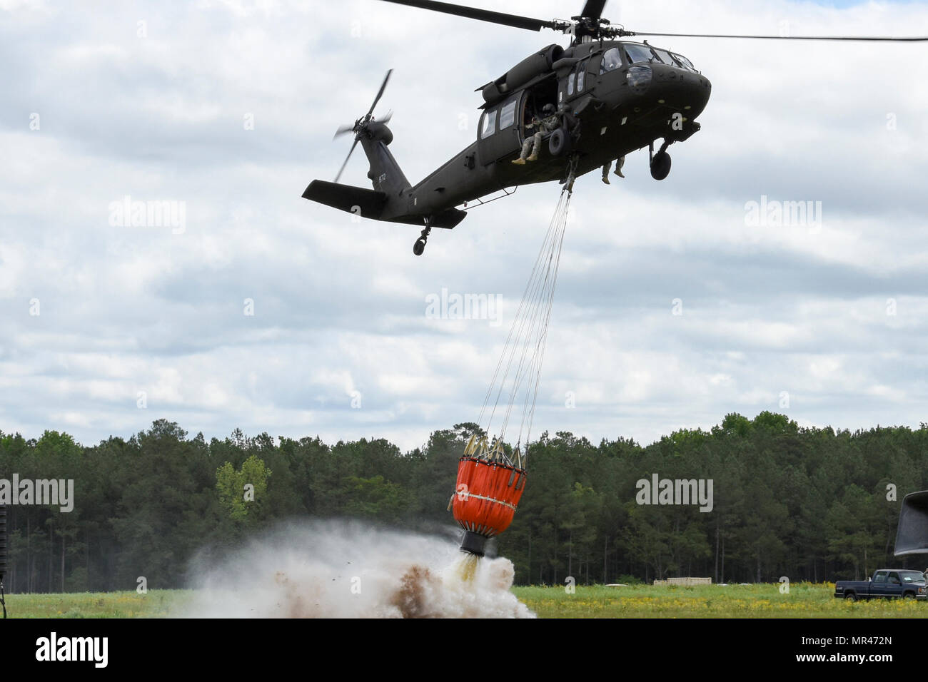 Ein US-Armee UH-60 Black Hawk Hubschrauber Tropfen Wasser aus einem Hubschrauber Eimer während einer Ausstellung auf der South Carolina National Guard Luft und Boden Expo in McEntire Joint National Guard Base, South Carolina, 5. März 2017. Diese Expo ist eine kombinierte Waffen Demonstration der Fähigkeiten von South Carolina National Guard Flieger und Soldaten beim sagen Danke für die Unterstützung der Kolleginnen und Kollegen SüdCarolinians und den umliegenden Gemeinden präsentiert. (Foto: US Army National Guard Staff Sgt Kevin Pickering) Stockfoto