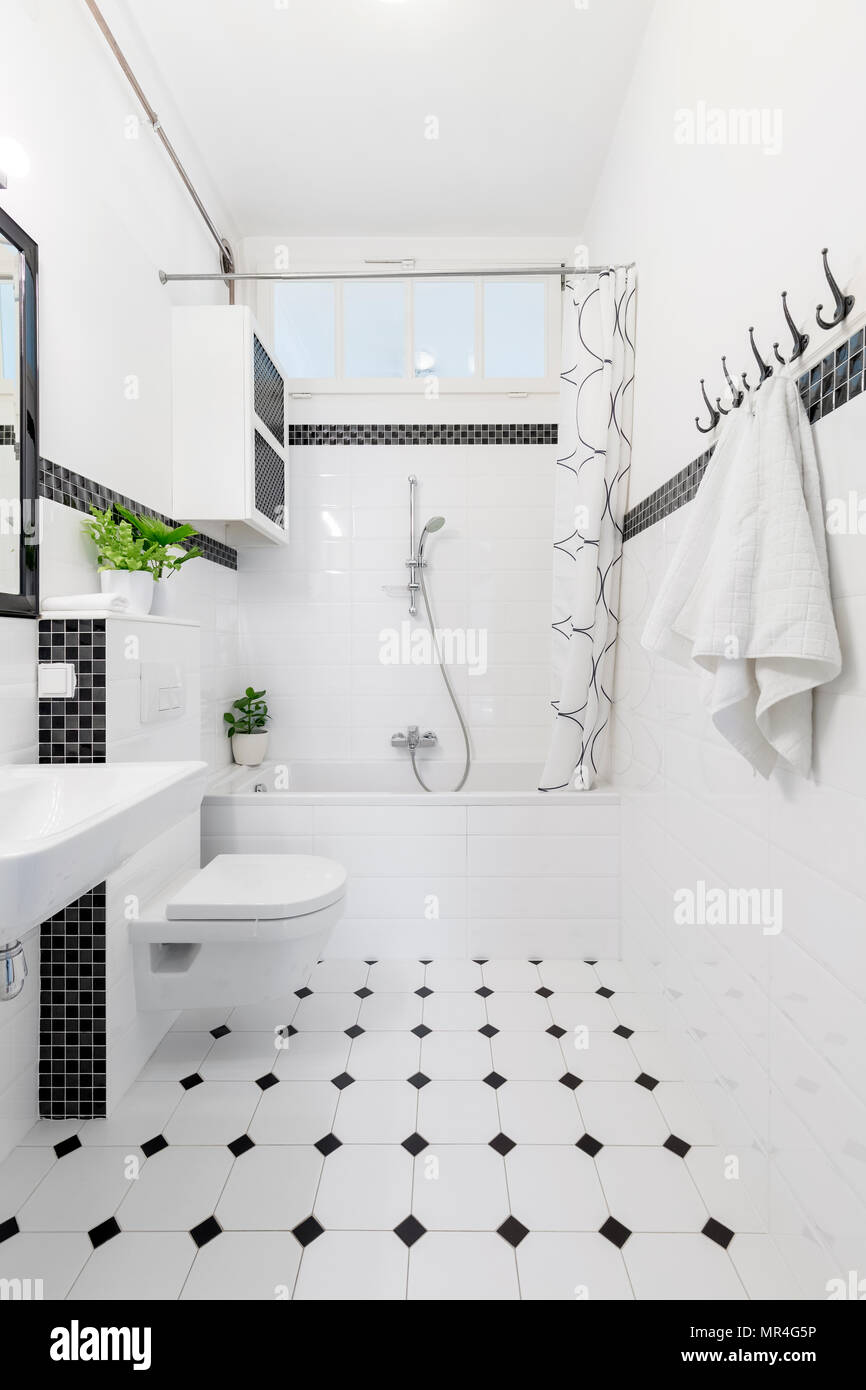 Gemusterte Boden in Weiß und Schwarz Bad mit WC und Badewanne. Real Photo Stockfoto