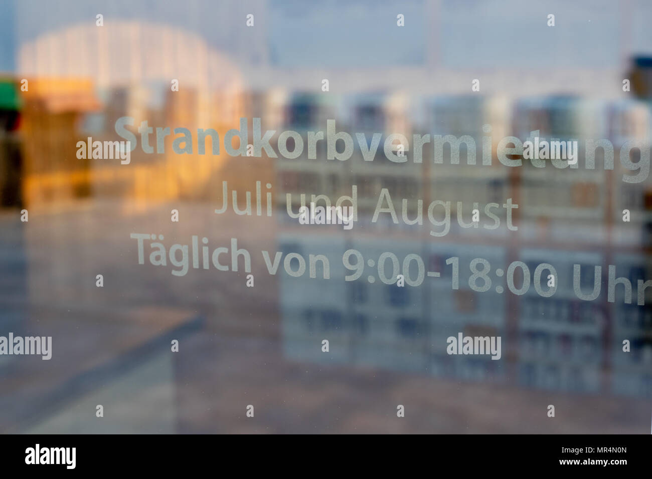 In der Nähe der Zeichen bei glastür Anzeige die deutschen Wörter für: Strandkorbverleih täglich von Juli bis August verfügbar zwischen 9.00 und 18.00 Uhr Stockfoto