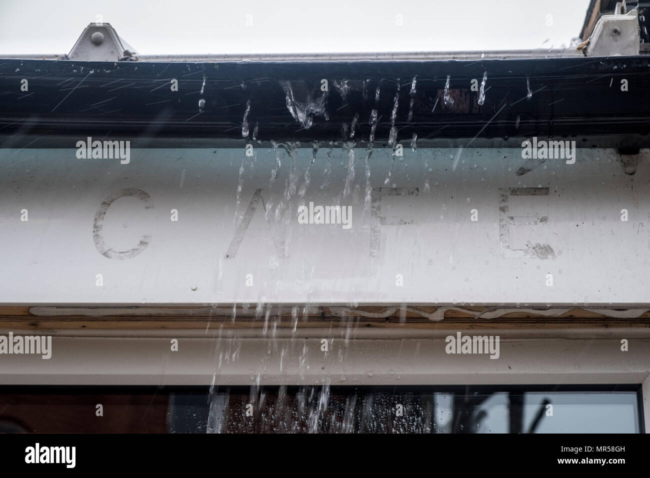 Überlaufende Regenrinne bei schwerem Regen. Regenwasser gießen aus der Regenrinne bei einem Sintflutartigen Regenguss, Nottinghamshire, England, Großbritannien Stockfoto