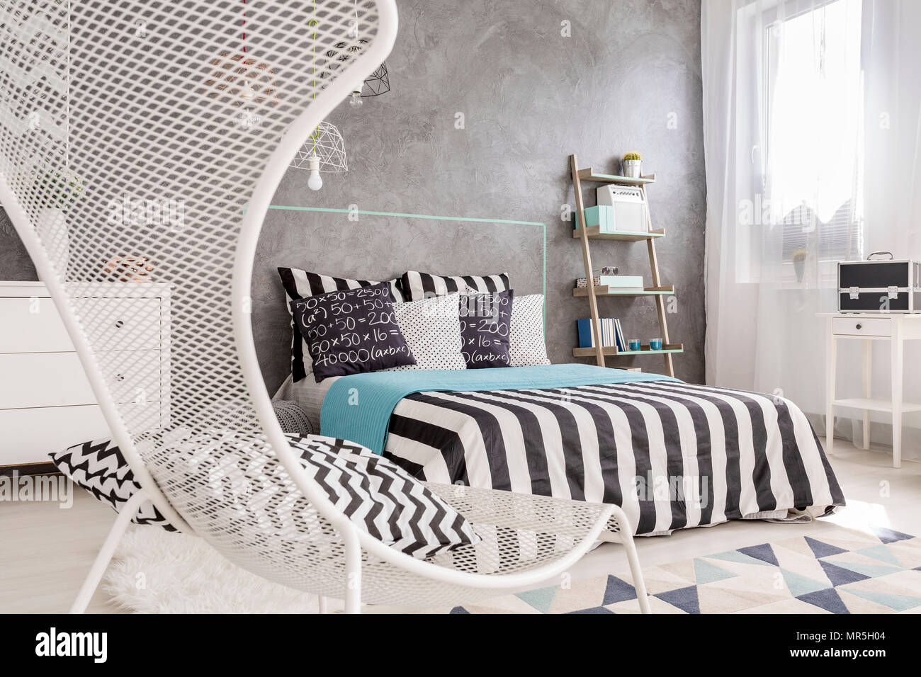 Modernes Schlafzimmer mit weißer Stuhl, großes Bett und dekorative Wand fertig stellen Stockfoto