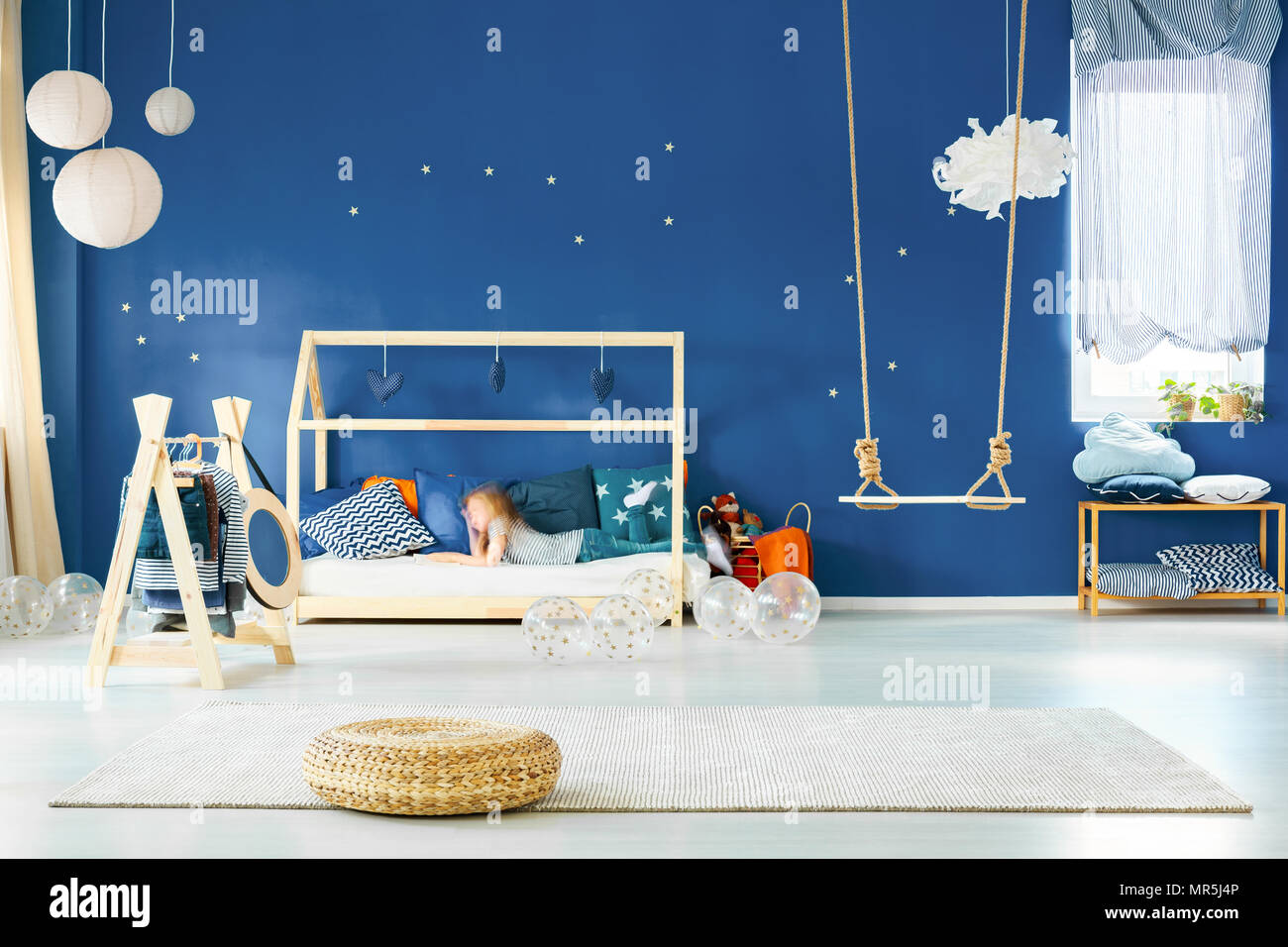 Moderne Mädchen Zimmer mit Schaukel, Bett und marine blau Wand Stockfoto