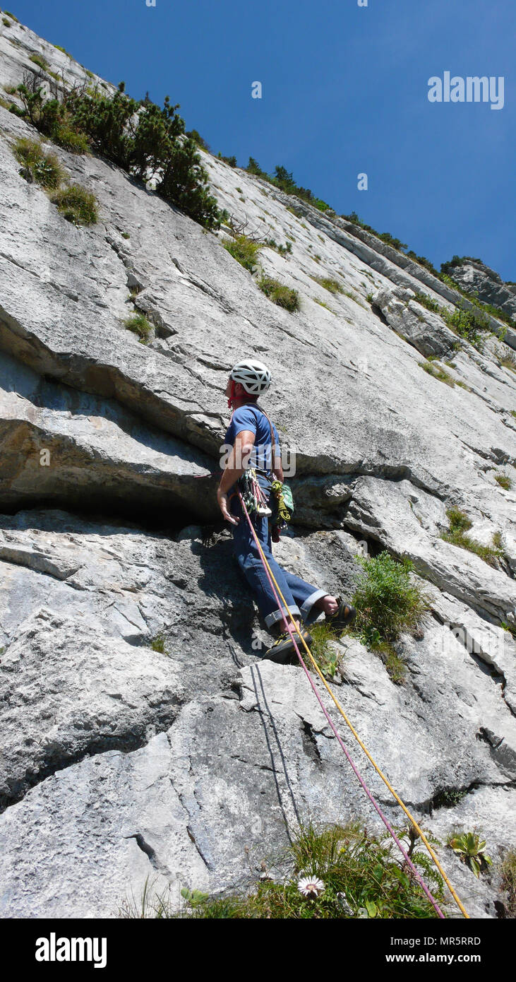 Bergführer an einem steilen Platte Tonhöhe einer hard rock climbing Route in den Alpen der Schweiz Stockfoto