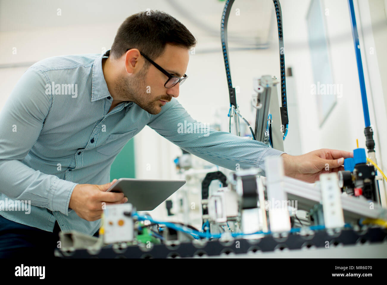 Portrait von gutaussehenden jungen Mann in der elektronischen Werkstatt mit digitalen Tablet Stockfoto