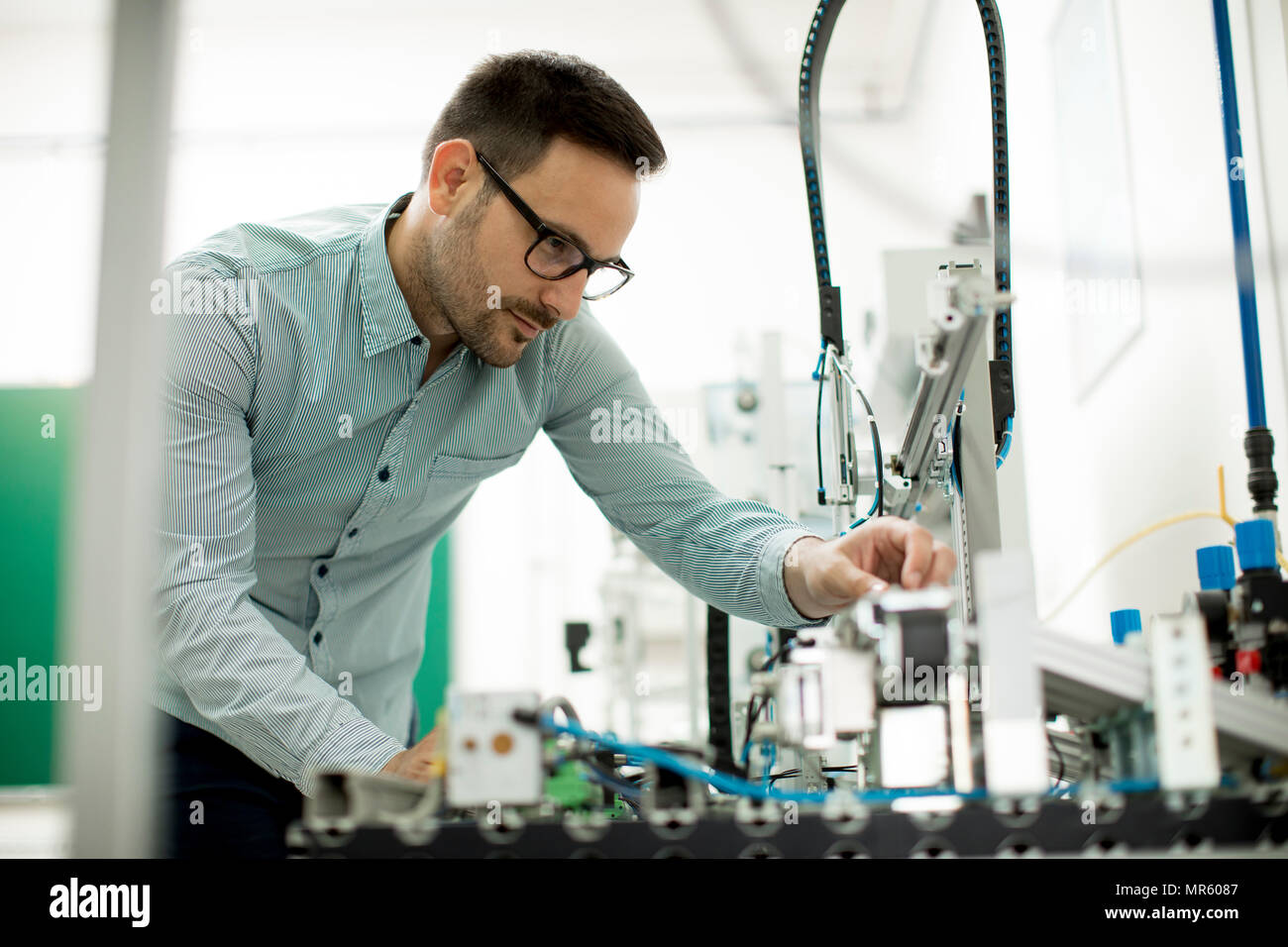 Hübscher junger Mann, der in der elektronischen Werkstatt Stockfoto