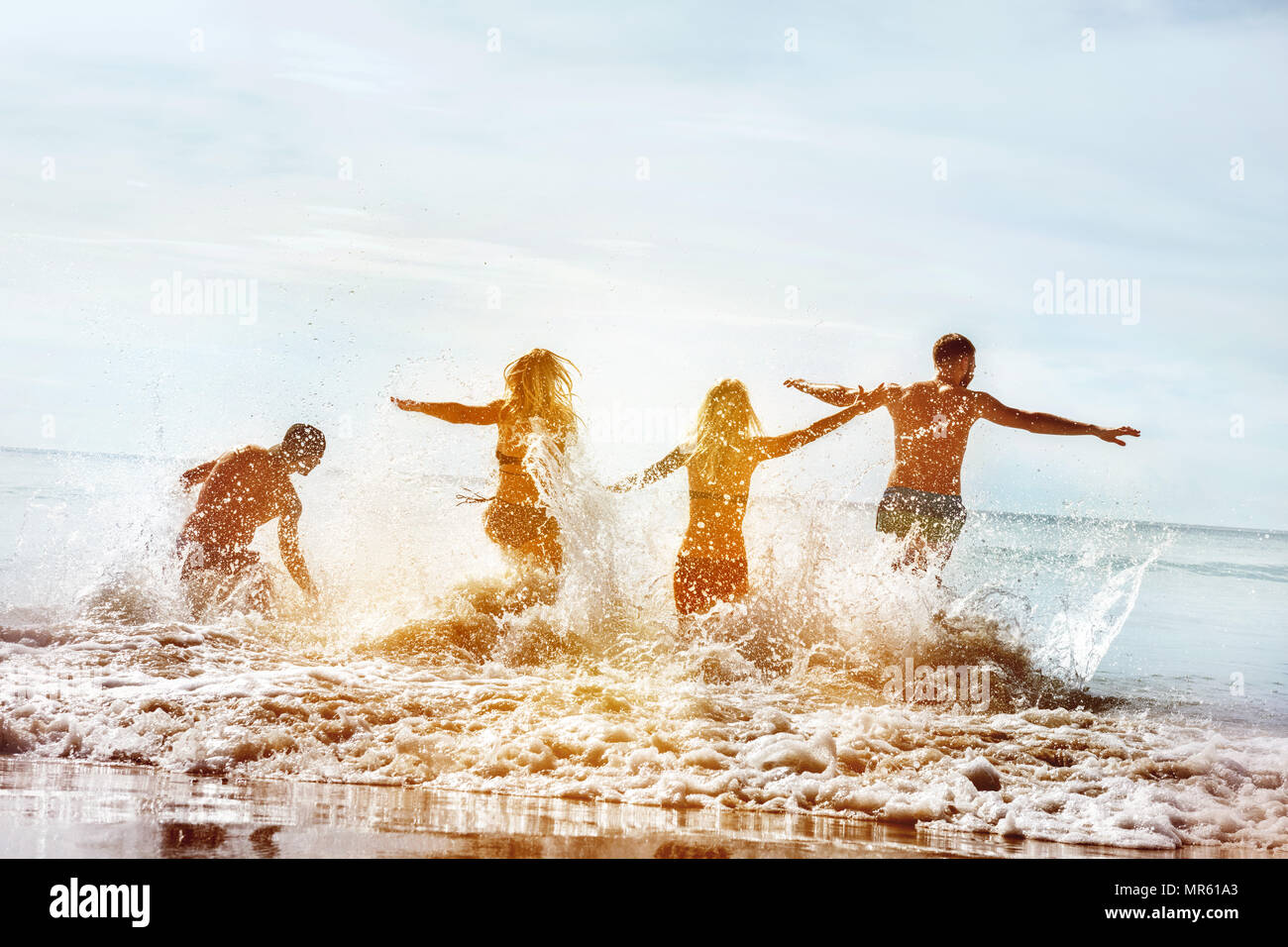 Gruppe von vier glückliche Touristen und Springen am Meer Strand Stockfoto
