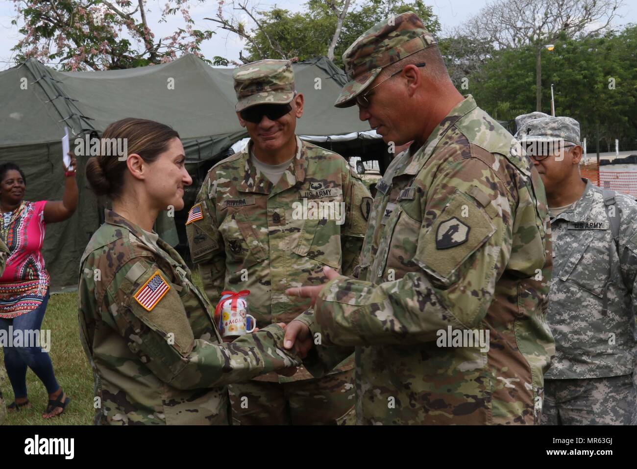 Command Sergeant Major Angel Rivera und Oberst John Simma, beide servieren mit 210. regionale Selbsthilfegruppe aus Puerto Rico, Geschenk einer Mutter Tag, Kapitän Anne-Marie Octavio, die als eine Krankenschwester-Praktiker für Wyoming Nationalgarde Medical Detachment dient. Octavio und ein Team von Medizinern haben freie Gesundheitspflege bei Beyond the Horizon 2017 verwaltet. (Foto: US-Armee Sgt. 1. Klasse Whitney Houston) Stockfoto