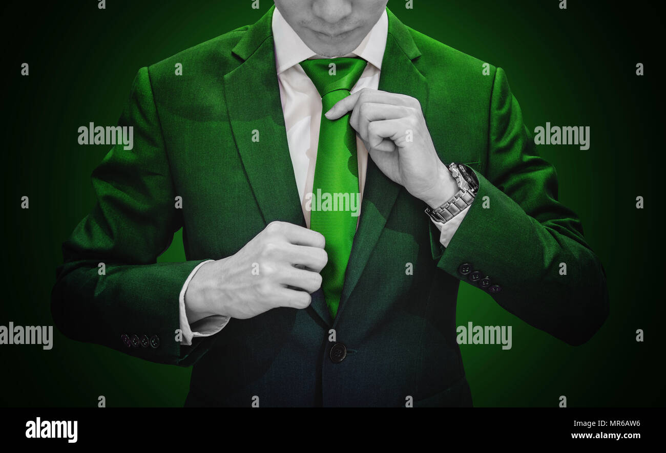 Unternehmer im grünen Anzug grün Krawatte binden. Umwelt, Landwirtschaft und Green Business Stockfoto