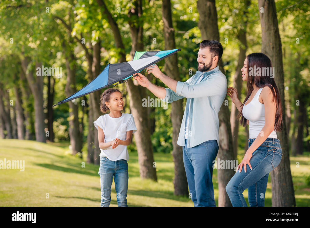 Vater, Tochter einen Drachen zu starten, während Sie die Zeit gemeinsam in Park Stockfoto