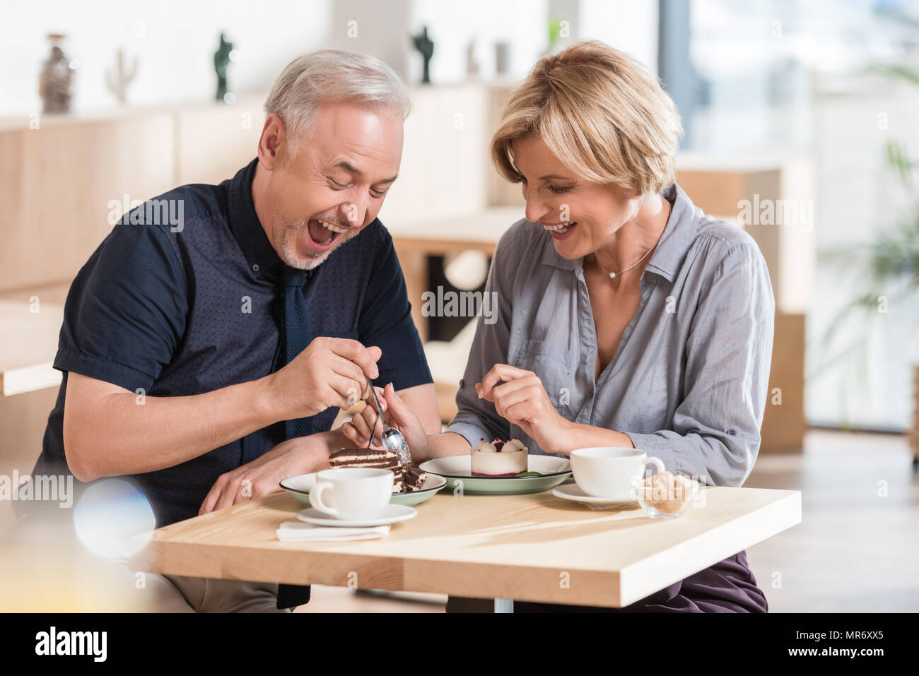 Mann und Frau Süßigkeiten essen im Cafe Stockfoto
