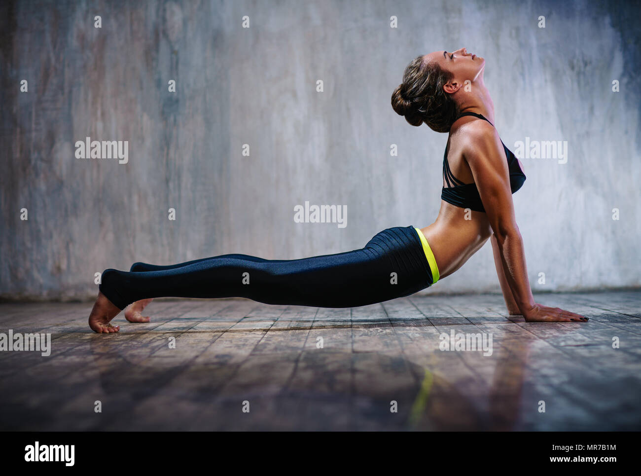Junge schlanke sportliche Frau stretching auf Stein Wand Hintergrund Stockfoto
