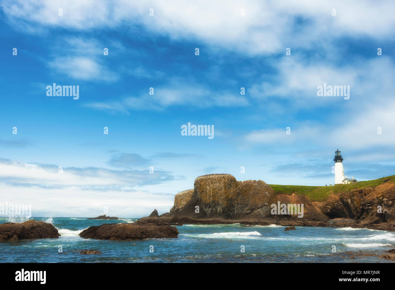 Big Sky bieten Copyspace in dieser Ansicht der Yaquina Head Lighthouse von unten auf Kopfsteinpflaster Strand bei Yaquina Head State Park an der Küste von Oregon Newport Stockfoto