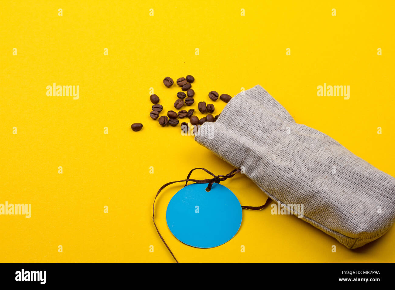 Sackleinen Sack voller Kaffeebohnen auf gelbem Hintergrund Stockfoto