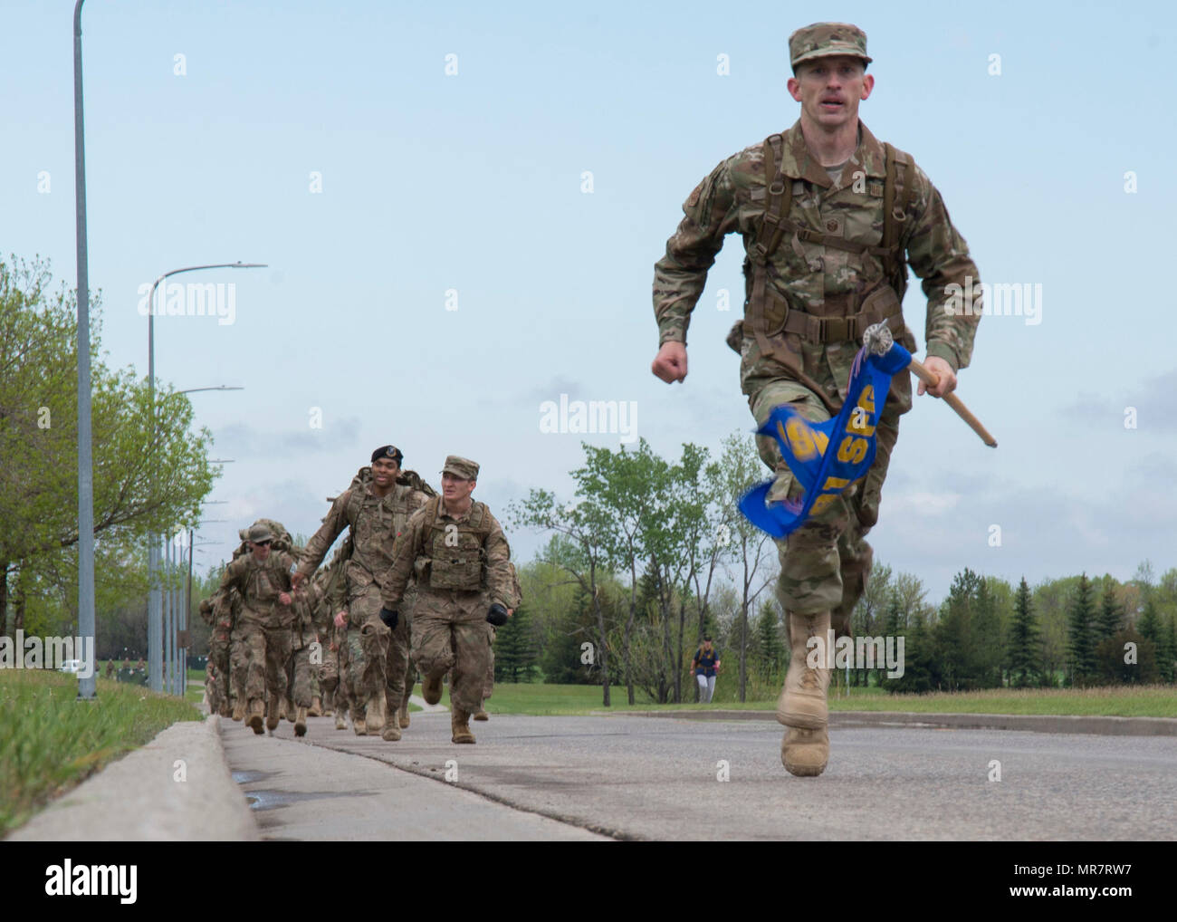 Master Sergeant Christopher Davis, 791st Rakete Sicherheit Kräfte Squadron First Sergeant, sprintet um 5 K Erinnerung Ruck März auf der Minot Air Force Base, N.D., 16. Mai 2017 beenden. Mitglieder, die den ersten Platz drehte sich um und motivieren, die Gruppe um gemeinsam stark zu beenden. (U.S. Air Force Photo/Flieger 1. Klasse Alyssa M. Akers) Stockfoto