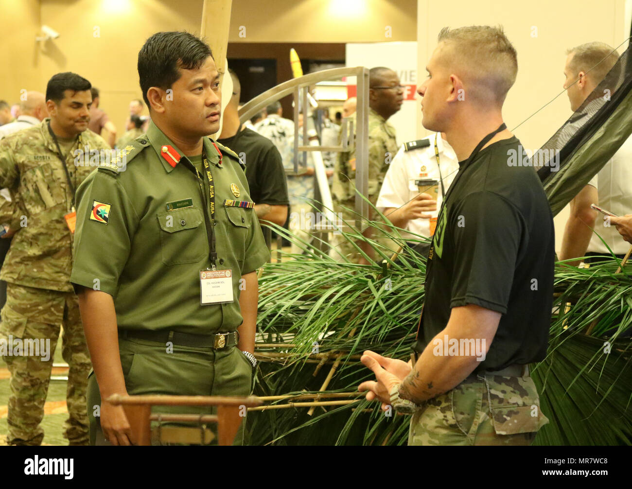 Staff Sgt. Shaun Thompson, ein Dschungel Schule Ausbilder mit 25 Infanterie Division Blitz Akademie, bespricht die Dschungel Schule Lehrplan zusammen mit Erfahrungen mit Kol. Haszaimi Bol Hassan, mit der Royal Brunei Land erzwingen, während das Land Forces Pacific (LANPAC) Symposium, 24. Mai im Sheraton Waikiki in Honolulu, HI. Us-Armee Führer, sowie gemeinsame und regionale Partner, diskutieren und präsentieren die entscheidende Rolle der Pazifischen Landstreitkräfte während der dreitägigen Veranstaltung. Stockfoto