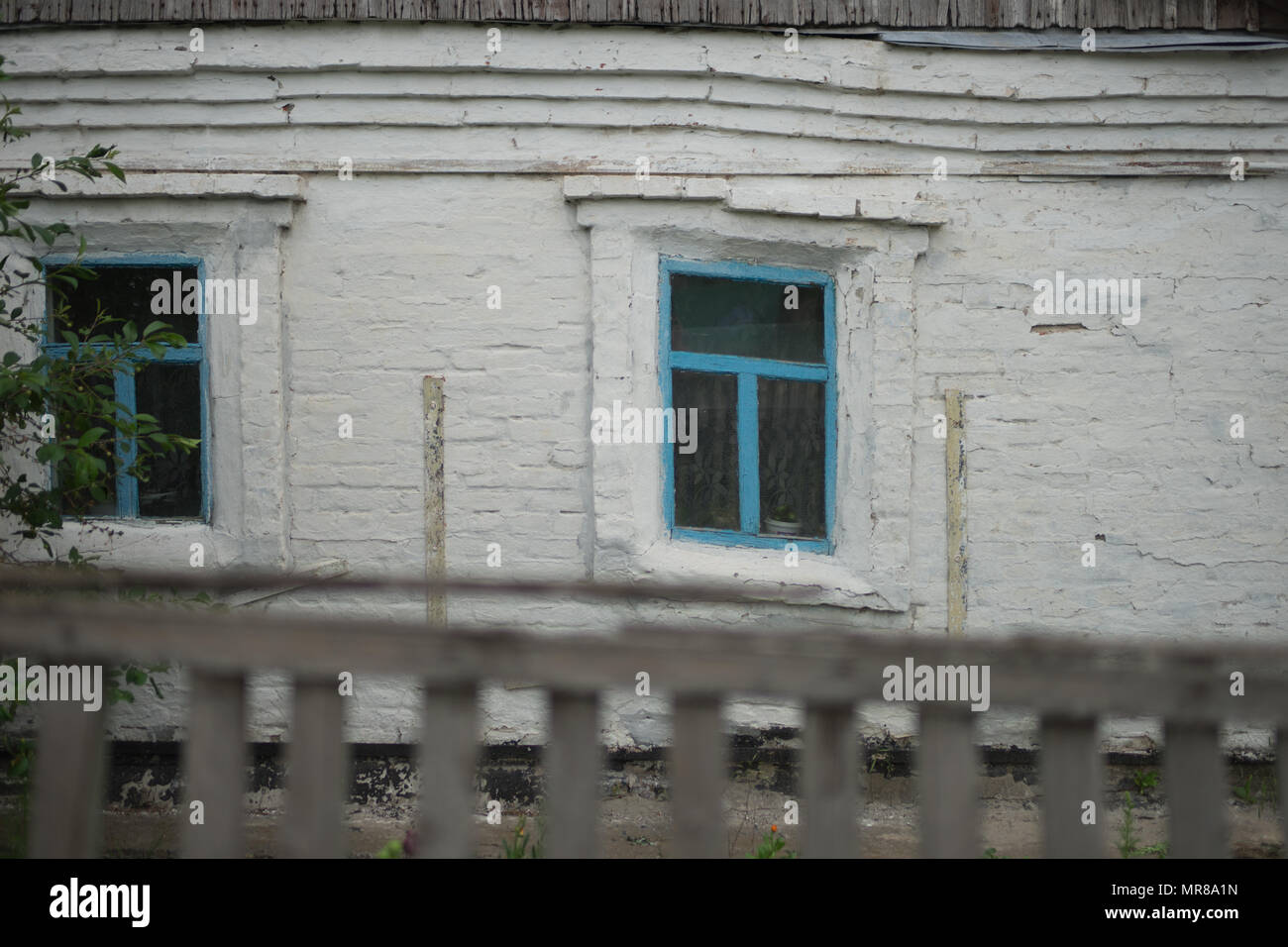 Die Wand eines alten Hauses mit schlaffer Windows Stockfoto