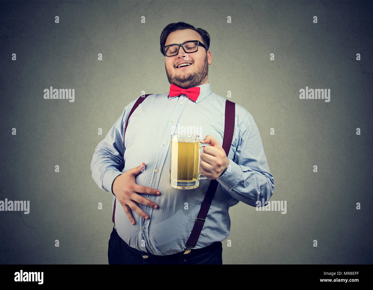 Junge übergewichtige glücklicher Mann mit potbelly Bier trinken sein Getränk genießen. Stockfoto