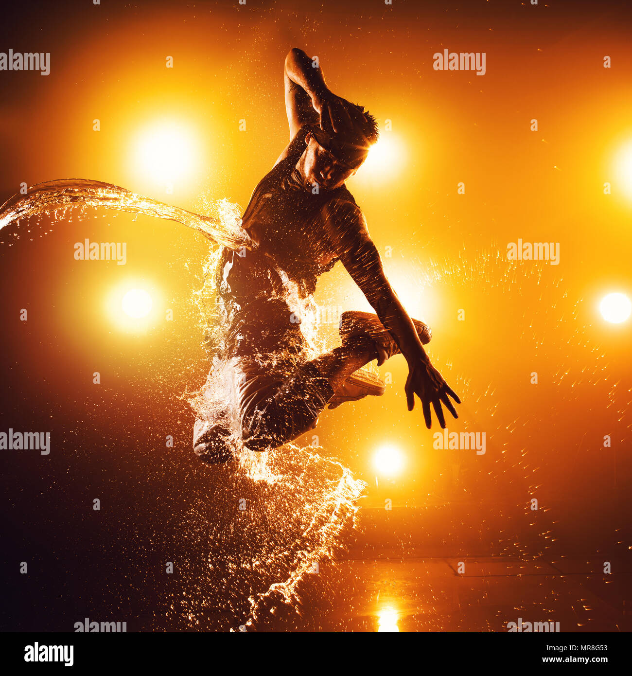 Junger Mann Breakdancer mit Licht- und Wassereffekte. Tattoo auf der Hand. Stockfoto