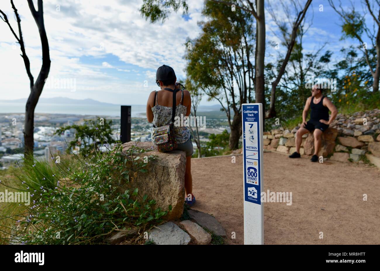 Frau nimmt ein Foto von Townsville in der Nähe des Cudtheringa track Meilenstein Abstand Zeichen signage ging, Castle Hill, QLD 4810, Australien Stockfoto