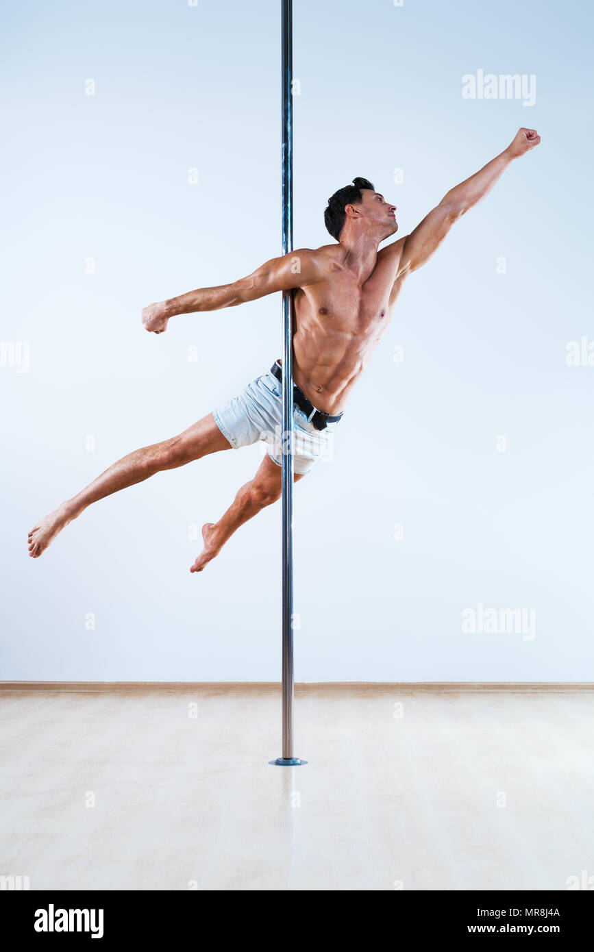 Junge Pole Dancing Mann auf weißen und blauen Wand Hintergrund Stockfoto