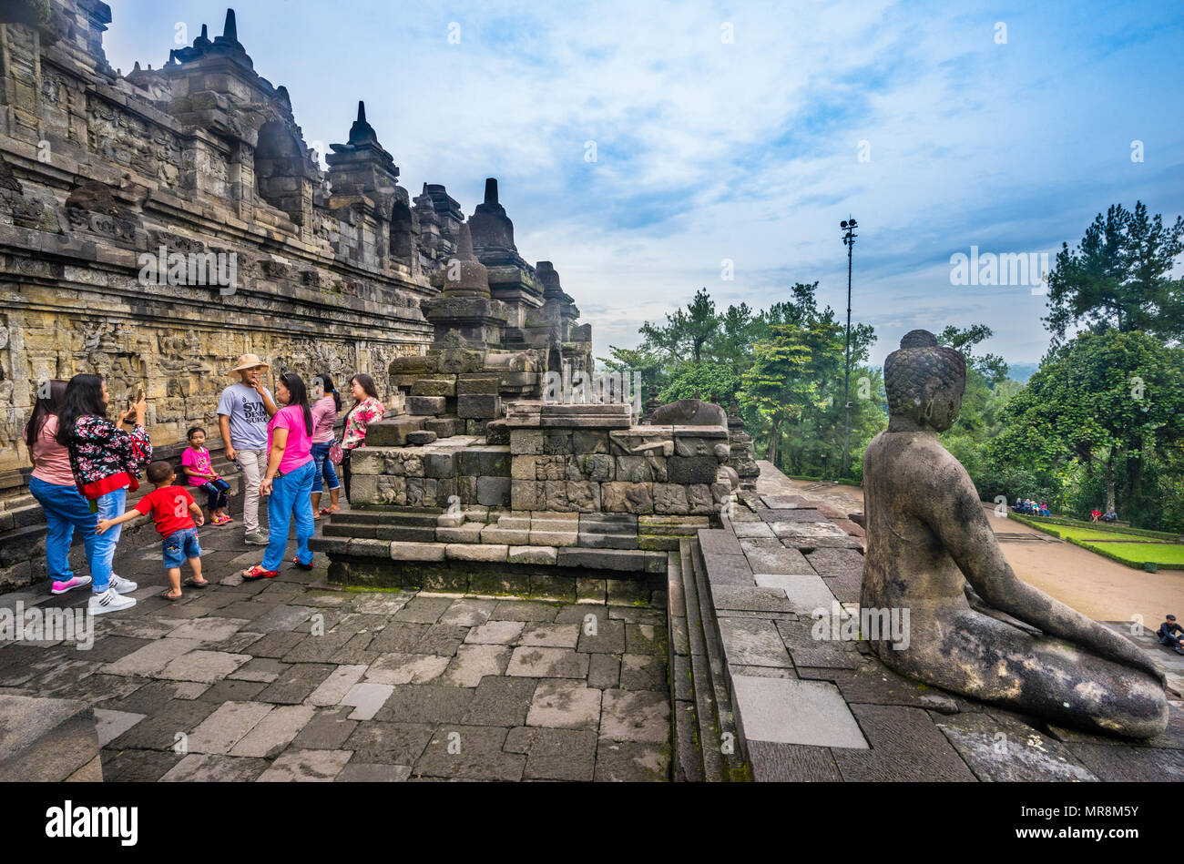 Besucher bewundern die Reliefs, erzählt eine umfassende buddhistische Erzählung am Borobudur buddhistischen Tempel, Zentraljava, Indonesien Stockfoto