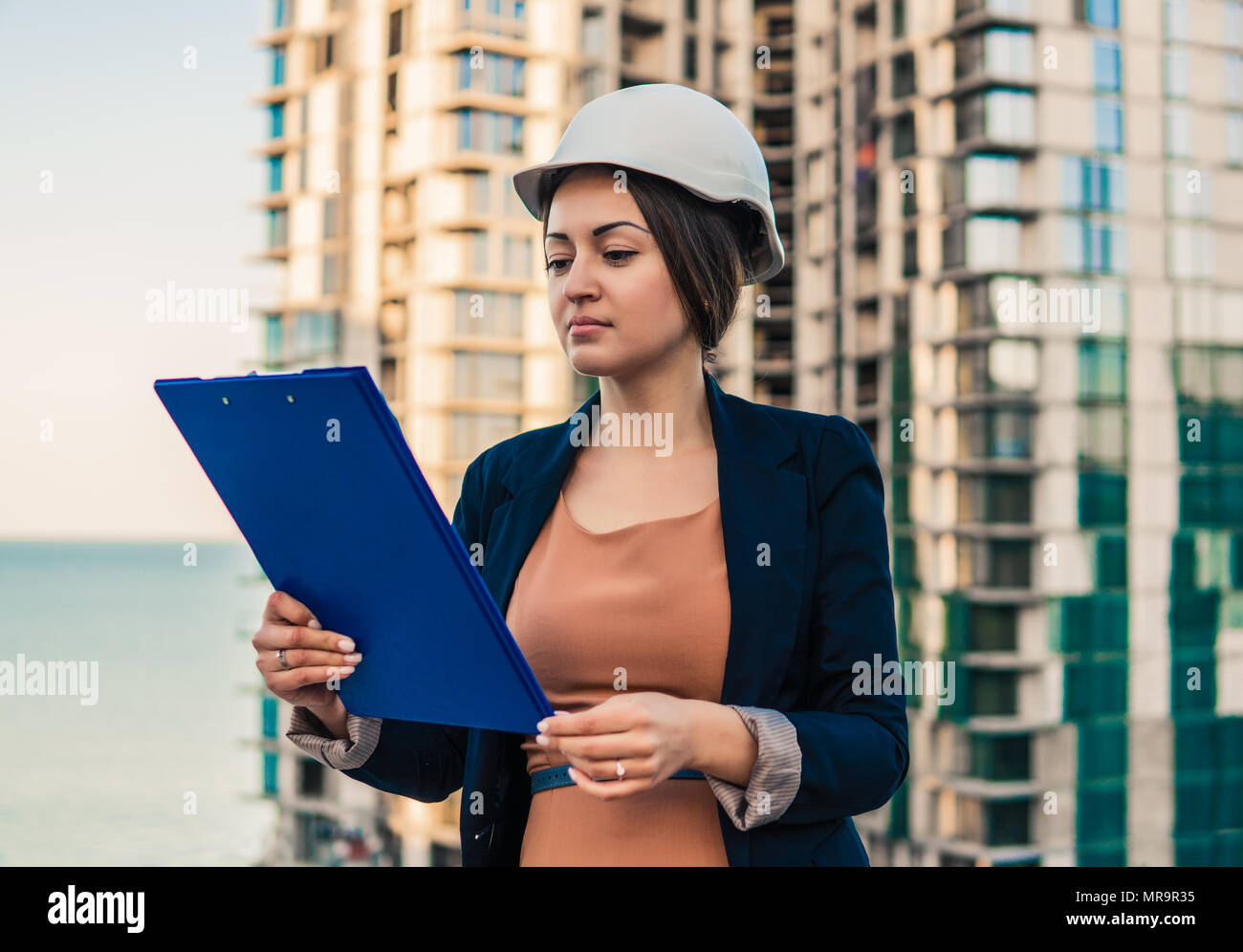 Wunderschöne Business woman Ingenieur steht mit plan Papiere. Stockfoto