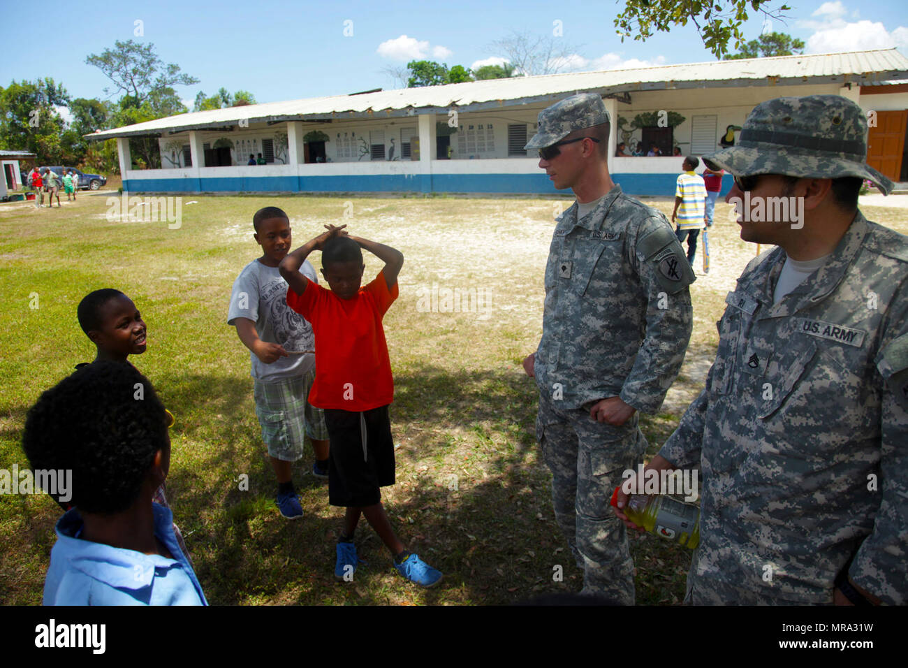 Staff Sgt. Salil Puri und SPC. Kyle Grimshaw, beide mit 344 Psychologische Operationen Unternehmen, sprechen mit einer Gruppe von Studenten aus dem Belize ländlichen Grundschule, 12. April 2017, im Doppelzimmer Kopfkohl, Belize. Die Soldaten verbrachten den Tag mit den Studierenden als Teil einer Community Relations Veranstaltung an der Schule zur Unterstützung der über den Horizont 2017 statt. Über den Horizont hinaus ist ein US Southern Command - geförderte, Armee südlich-led-Übung für humanitäre und technische Dienstleistungen für die Gemeinschaften in der Notwendigkeit, die Unterstützung der USA für Belize zur Verfügung zu stellen. Stockfoto