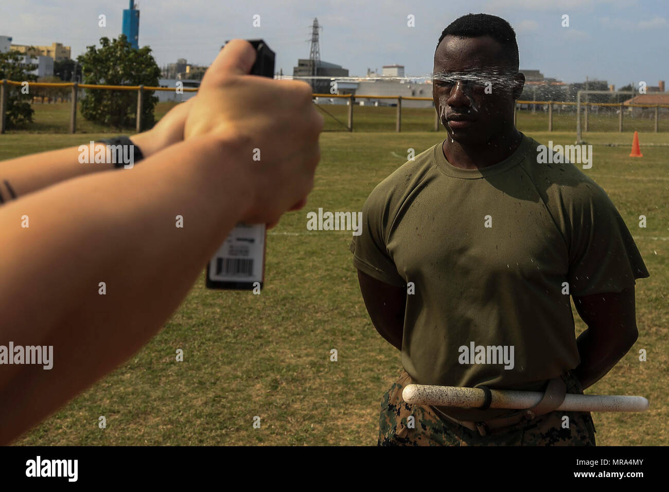 Ein US-Marine zugeordnet vorübergehend zusätzliche Pflicht, Propst Marschallamt, Marine Corps Base Camp Butler, beteiligt sich an Oleoresin Capsaicin (OC) Spray als Teil einer Sicherheit Augmentation Force (SAF) Qualifikationsturnier auf Lager Kinser, Okinawa, Japan, 14. April 2017. Die SAF Marines sind erforderlich Stufe 1 OC Kontamination zu empfangen, um zu wissen, wie der ordnungsgemäße Funktion und Sicherheit bieten, während Sie von der Spray berührt wird. Stockfoto