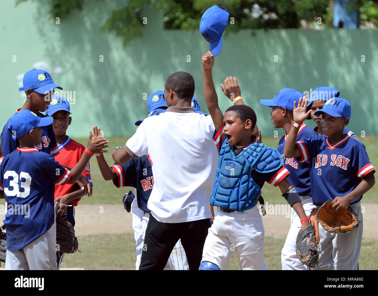 Ein Baseball Team feiert Sieg am Nachmittag Spiel während einer Baseball Clinic die Task Force für Bereich Kinder Mai 20, 2017, in San Juan de la Maguana, Dominikanische Republik gehostet wird, als Teil der neuen Horizonte 2017. Der baseball Clinic, die von der Task Force in Zusammenarbeit mit verschiedenen Nichtregierungsorganisationen und anderen Organisationen organisiert, bot US-Mitglieder die Möglichkeit, ehemalige Major League Baseball Spieler und Trainer auf ein denkwürdiges Ereignis für 450 Kinder, Eltern und andere Teilnehmer zu unterstützen. (U.S. Air Force Foto von Master Sgt. Karen J. Tomasik) Stockfoto