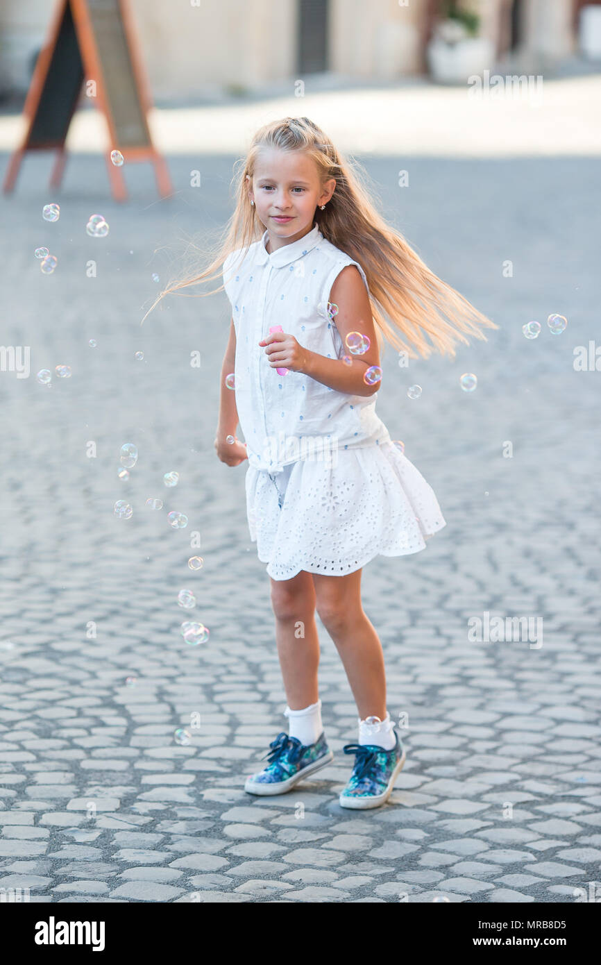 Adorable kleine Mädchen bläst Seifenblasen in Trastevere in Rom, Italien Stockfoto