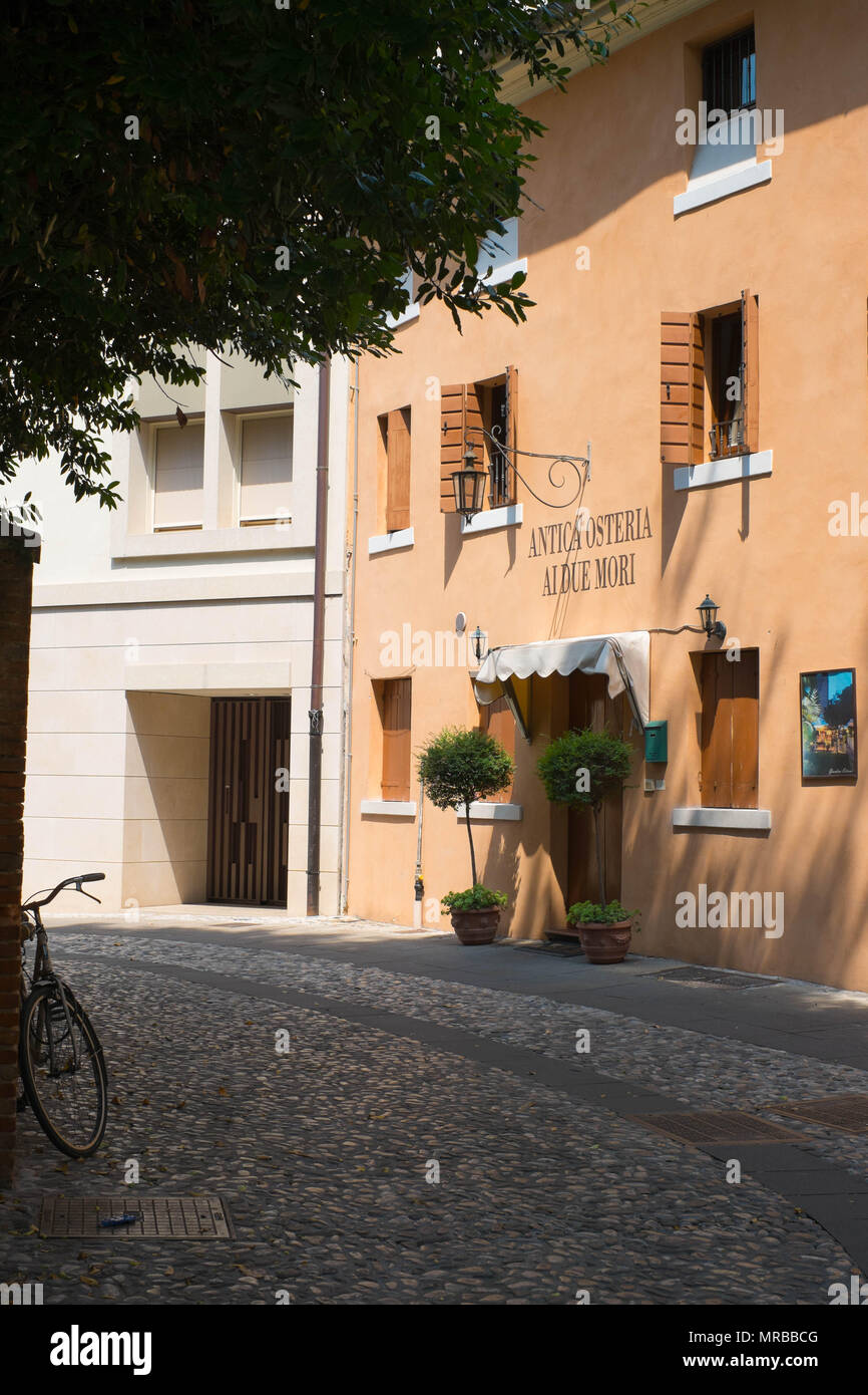 Eine kleine, ruhige Straße in Castelfranco Veneto. Ein Fahrrad steht an der gegenüberliegenden Seite der Fisch Restaurant "Ai Due Mori". Stockfoto