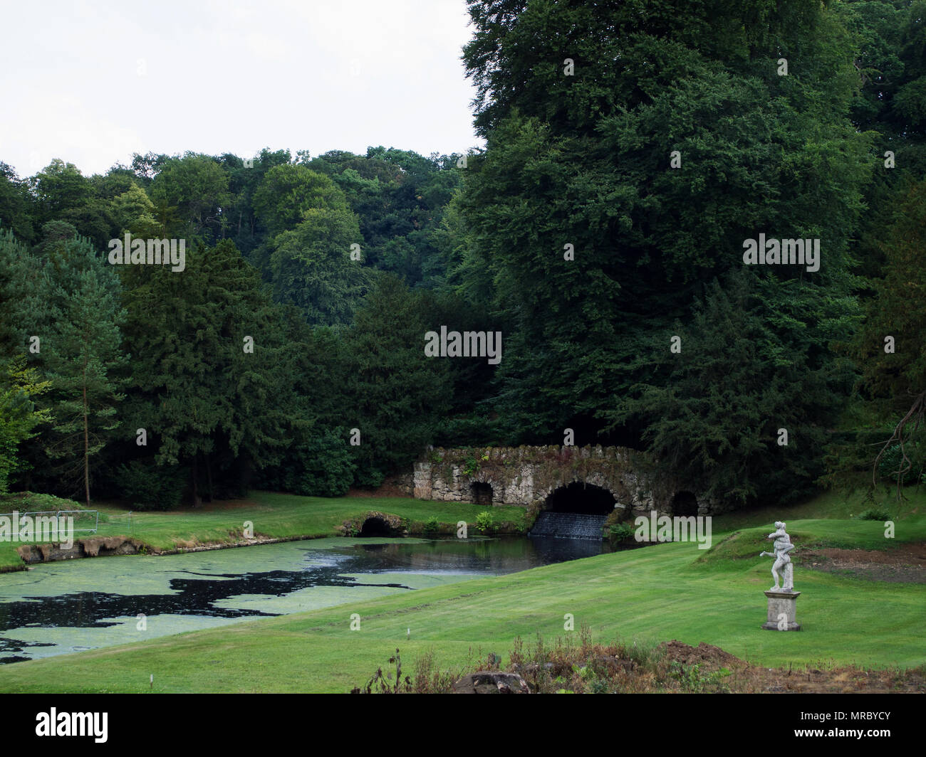 Steinerne Brücke des Flusses Skell im Garten von Fountains Abbey, Ripon, Großbritannien Stockfoto