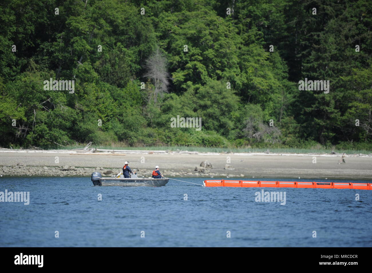 Zwei Männer an Bord eines Skiff, aus der Armee Korps von Enigneers Seattle Bezirk, ein 300 Fuß Abschnitt der Boom als Teil einer melden Sie verschütten Übung aus Blake Island, Washington, 6. Juni 2017. Die Übung simulierte eine gemeinsame Agentur Antwort auf eine unbekannte Ölpest vor der Insel, mit Mitgliedern aus dem Korps, Coast Guard 13. Bezirk, die muckleshoot Indian Tribe, Marine Region Nordwesten, die Washington Department für Ökologie und der Washington State Parks und Erholung Kommission bei der Teilnahme. U.S. Coast Guard Foto von Petty Officer 3. Klasse Amanda Norcross. Stockfoto