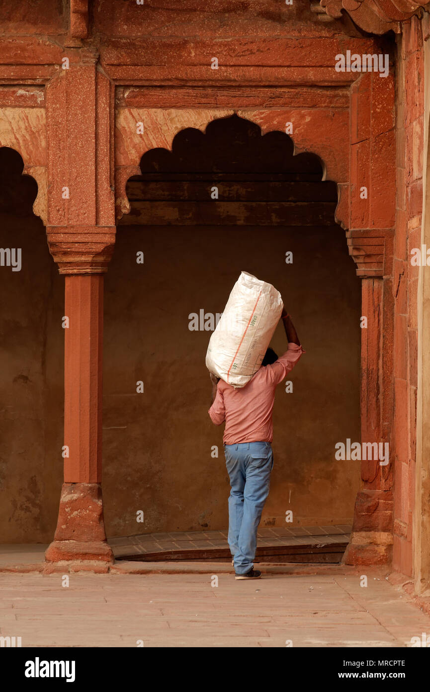 Agra, Indien - November 29, 2015: Ein indischer Mann'n Sack auf die Schulter in der historischen Roten Fort von Agra - ein UNESCO Weltkulturerbe Stockfoto