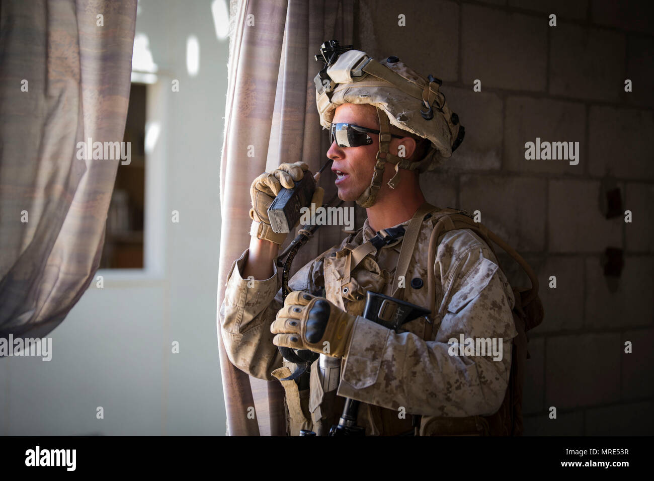 MARINE Corps Air Ground Combat Center Twentynine Palms, Kalifornien - Cpl. Kevin Masellah, ein squadleader mit 3 Platoon, Golf Company, 2nd Battalion, 7th Marine Regiment, kommuniziert mit seinen Mannschaftskameraden von feindlichen Personal im Bereich 200 bei einem städtischen Lane Training an Bord Marine Corps Air Ground Combat Center, Twentynine Palms, Kalifornien, 15. Mai 2017. Die urbanen Kriegsführung Paket, Teil der integrierten Übung 3-17, ist ein platoon - Ebene Bataillon - Größe evolution wo Marines urban patrouillieren geübt, bis zu einem Marine Air Ground Task Force Angriff auf eine gegnerische Stadt gehalten. Es Stockfoto