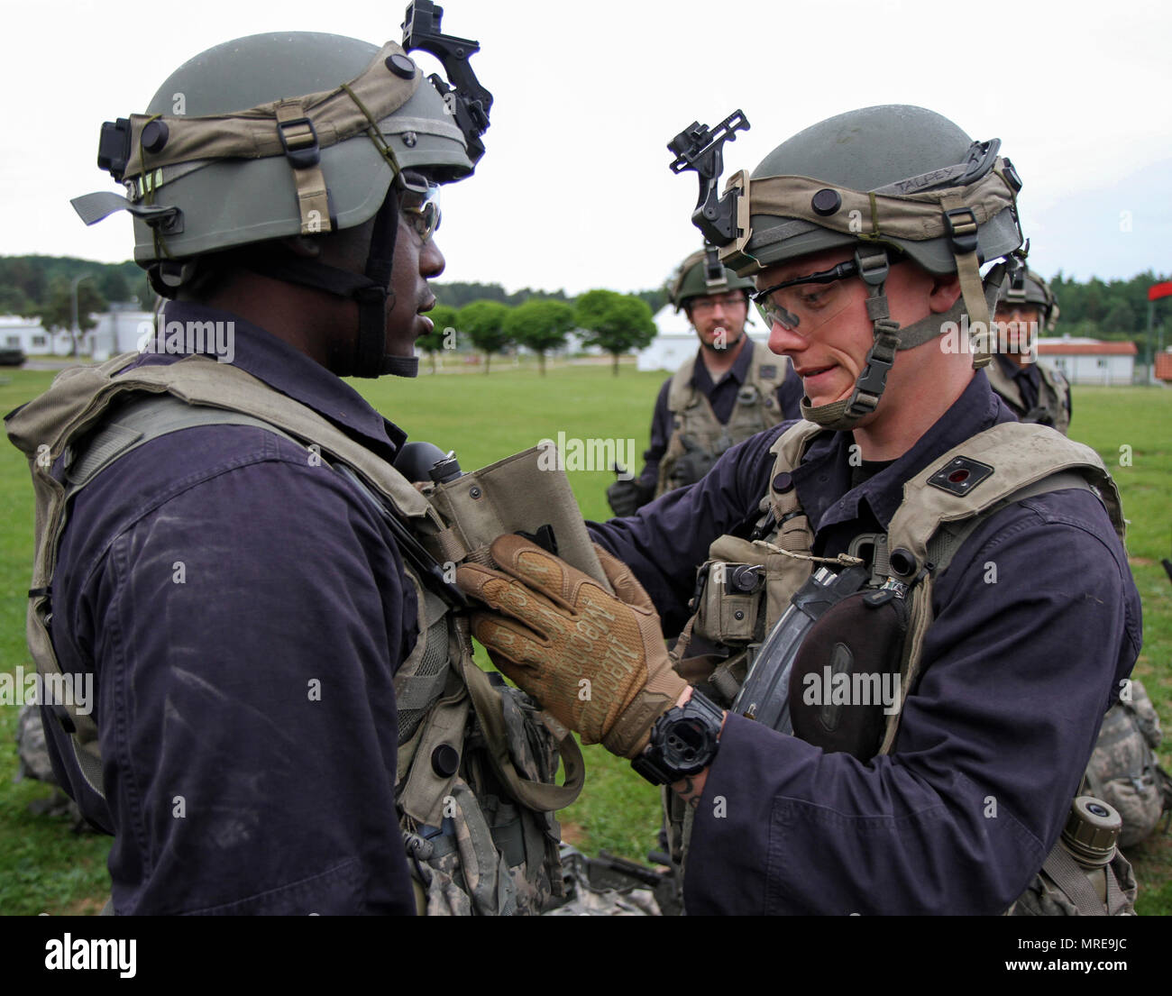 Spc. Ross Talpey, von Bridgewater, Massachusetts (rechts) führt vor der Bekämpfung der Kontrollen der anderen Squad Mitglied Pfc. Franklin Perry von Boston vor einer Nacht Mission während der jährlichen Ausbildung an der Joint Multinational Readiness Training Center in Hohenfels, Deutschland Juni 5, 2017. Die beiden Gardisten, zusammen mit Kolleginnen und Kollegen der Bravo Company, 1-182 nd Infanterie Regiment, Massachusetts Army National Guard dienen als die gegnerische Streitmacht, die in der übung kombinierte Lösen VIII, die rund 3.400 Mitarbeiter aus 10 Ländern. Das Ziel der Übung ist es, die Kräfte in Europa vorbereiten, zusammen zu t betreiben Stockfoto