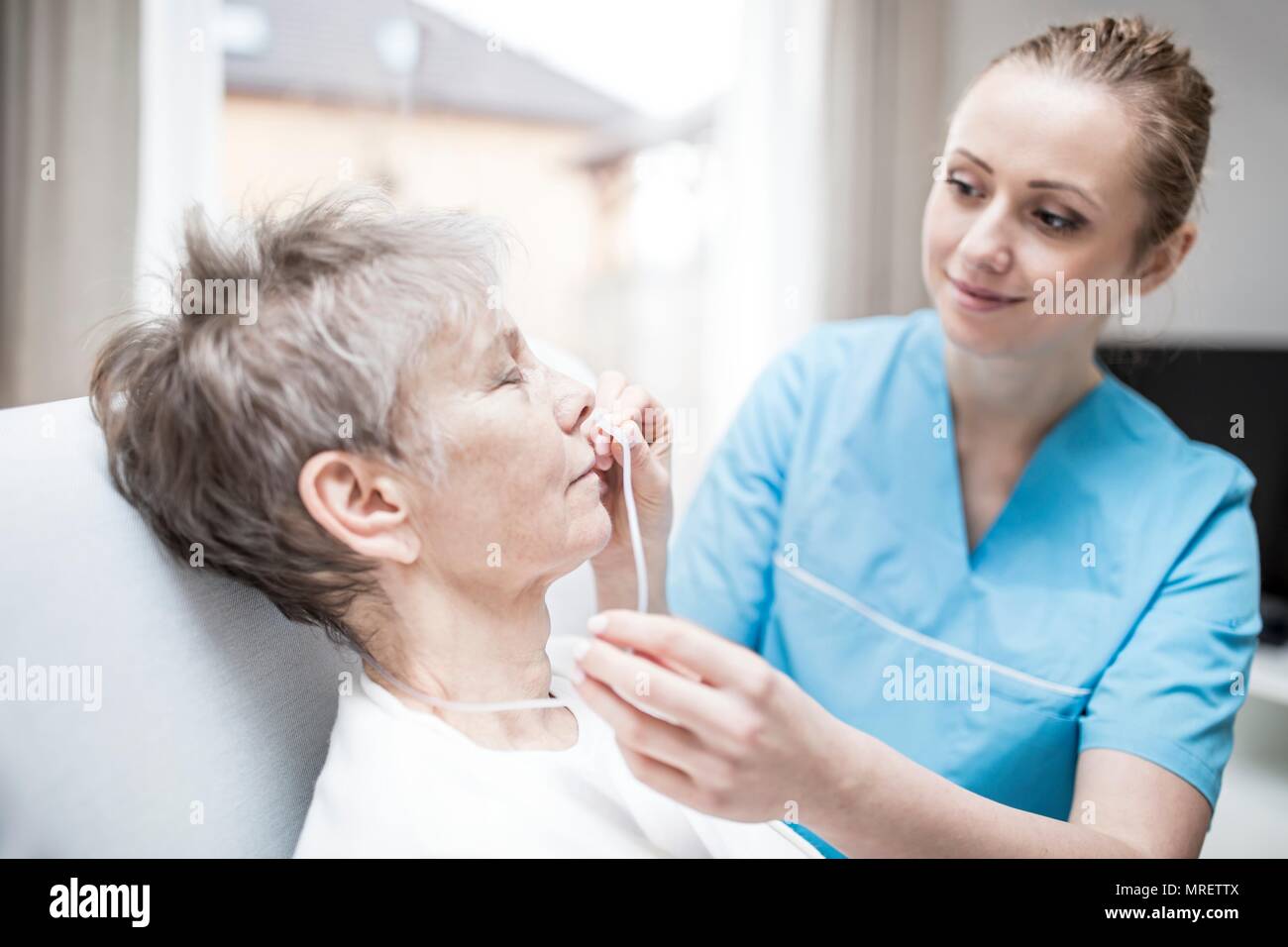 Care worker einfügen Nasal-sonde in der älteren Frau. Stockfoto