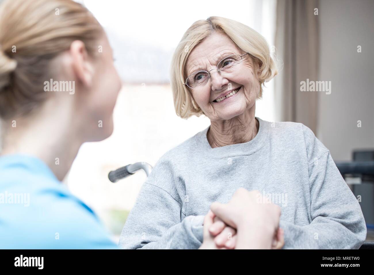 Ältere Frau bei Care worker lächelnd. Stockfoto